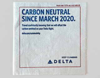 Delta airlines napkin displaying the message CARBON NEUTRAL SINCE 2020